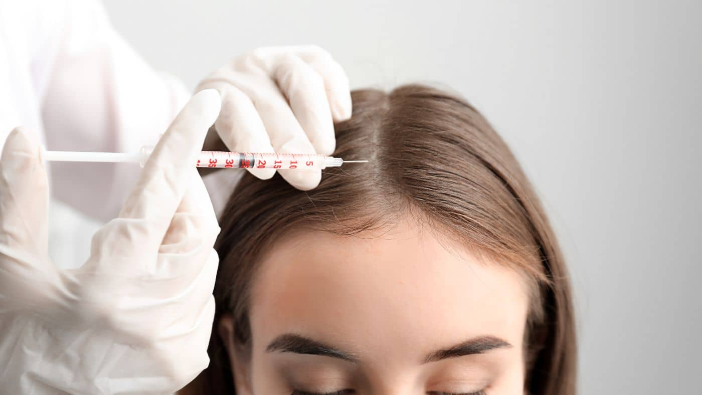 A person applying stem cell for hair treatment on their scalp at home