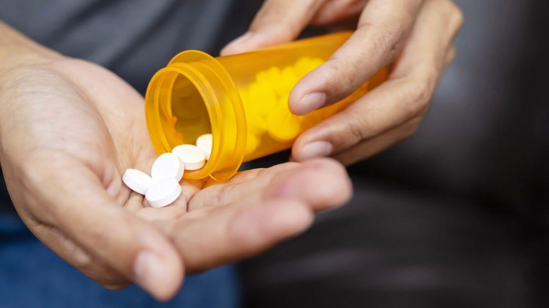 A man handling a bottle of hair loss medication